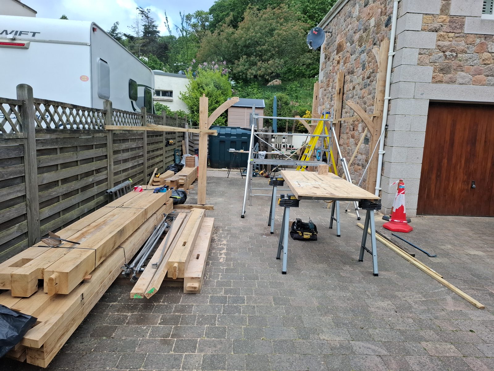 Beams set out along the drive: Oak carport in St Mary project photo 02